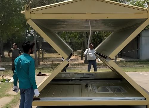 Collapsible modular container shelter being unfolded during installation at site