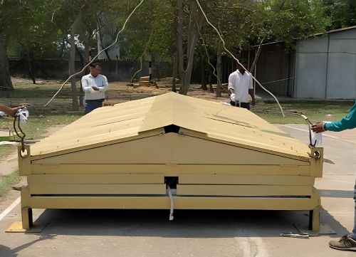 Collapsible modular container shelter in folded position ready for transport and installation