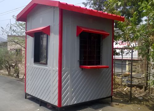 Portable security guard cabin with red roof trim and windows installed outdoors
