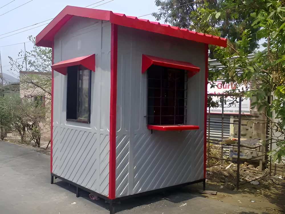 Portable security guard cabin with red roof trim and windows installed outdoors