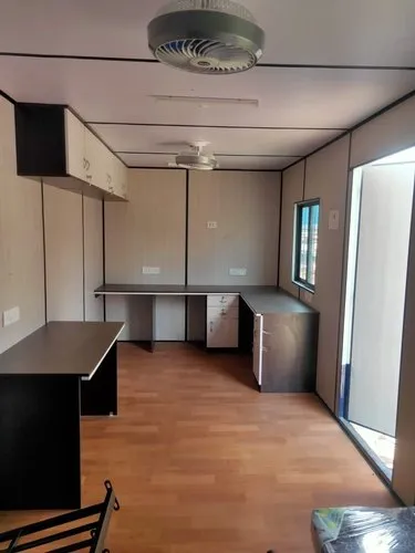 Interior of modular portable office cabin with workstations, storage cabinets and wooden flooring